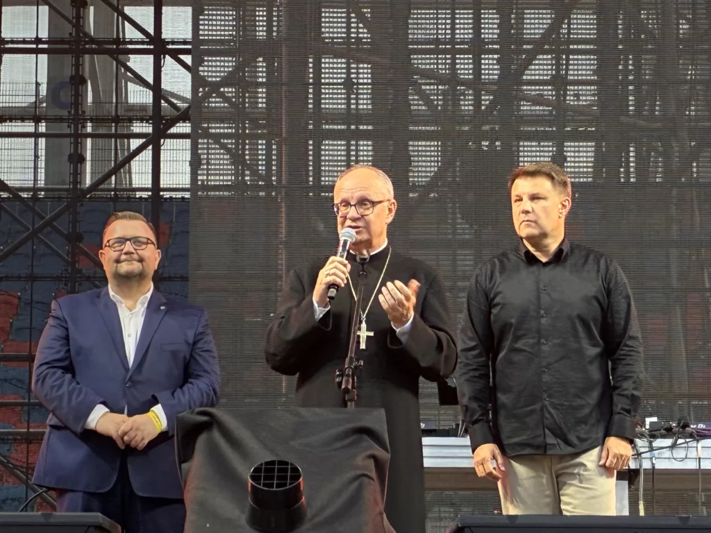 Three speakers, including a priest, address the audience at the inaugural concert at Itaka Arena.
